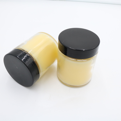La mano perfumada de la vela del tarro de cristal amarillo de la verbena del limón vertió velas de la soja con la tapa negra