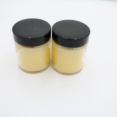La mano perfumada de la vela del tarro de cristal amarillo de la verbena del limón vertió velas de la soja con la tapa negra