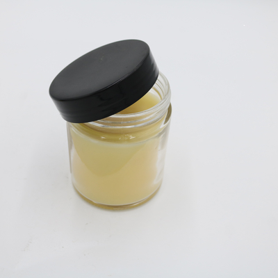 La mano perfumada de la vela del tarro de cristal amarillo de la verbena del limón vertió velas de la soja con la tapa negra